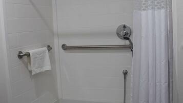 A walk-in shower with a glass door, a towel rack, and a shower curtain.