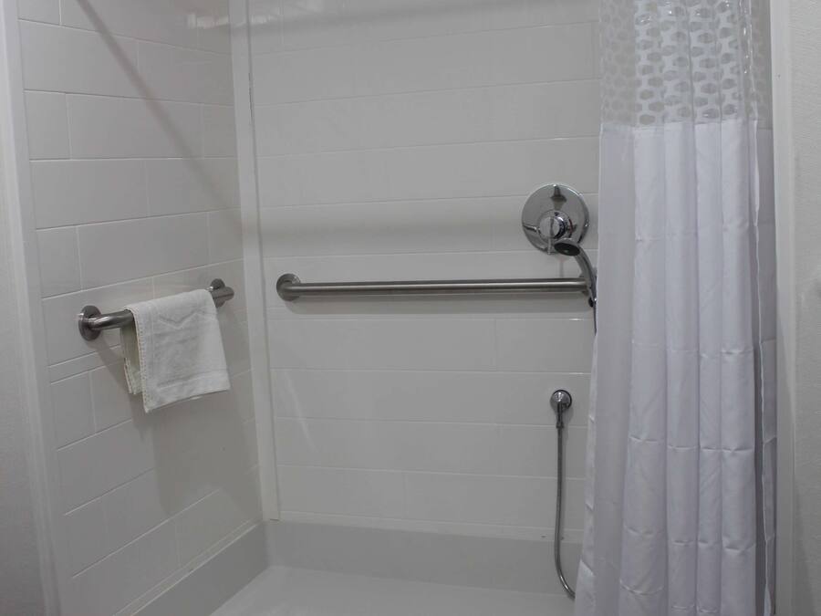 A walk-in shower with a glass door, a towel rack, and a shower curtain.