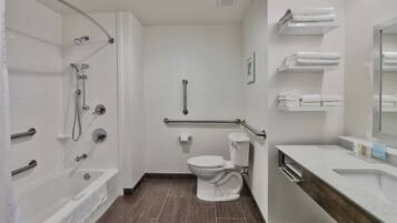 A modern bathroom with a bathtub, toilet, and vanity.