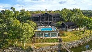 A large building with a swimming pool and a covered deck area. - Lake Barkley State Resort (Cadiz)
