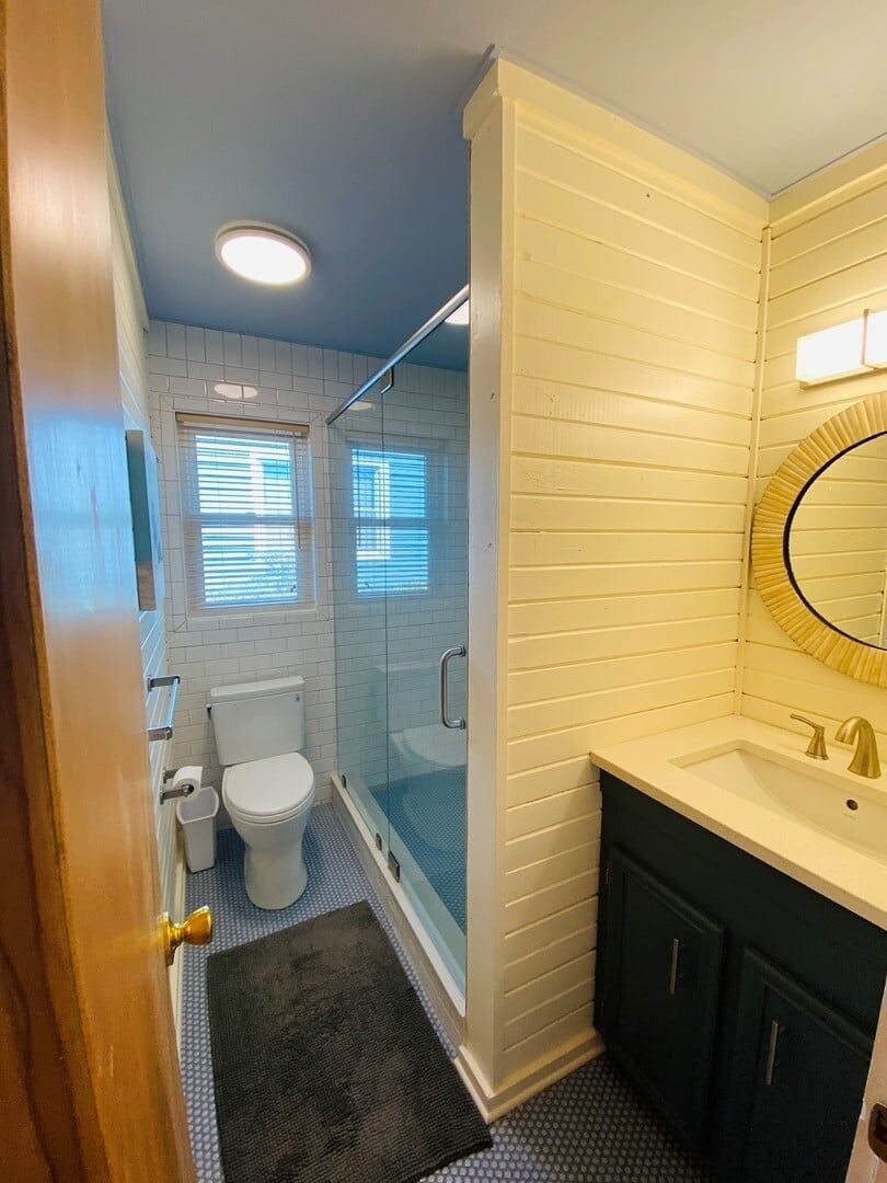 A bathroom with a toilet, a shower, and a sink.