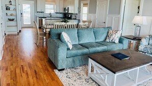 Un salon spacieux comprenant un canapé, une table basse et un coin repas avec des chaises et une table.