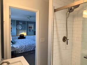 A bathroom with a shower, a sink, and a mirror. - How Sweet The Sound 3 Bedroom Home by RedAwning (Supply)