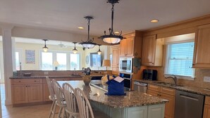 A spacious kitchen with a large island, wooden cabinets, and a built-in microwave. - Majak Moments 7 Bedroom Home by RedAwning (Supply)
