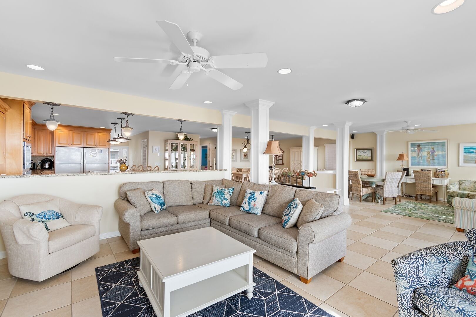 A spacious living area with a sectional sofa, a coffee table, and a dining area with chairs and a table.