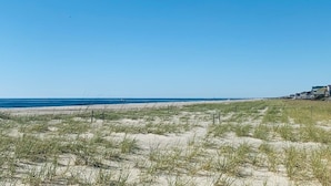A beach with sand dunes and a clear blue sky. - License To Chill 4 Bedroom Home by RedAwning (Supply)