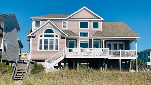 A multi-story house with a balcony, a staircase, and a view of the beach. - License To Chill 4 Bedroom Home by RedAwning (Supply)