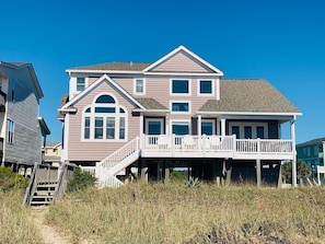 A multi-story house with a balcony, a staircase, and a view of the beach. - License To Chill 4 Bedroom Home by RedAwning (Supply)