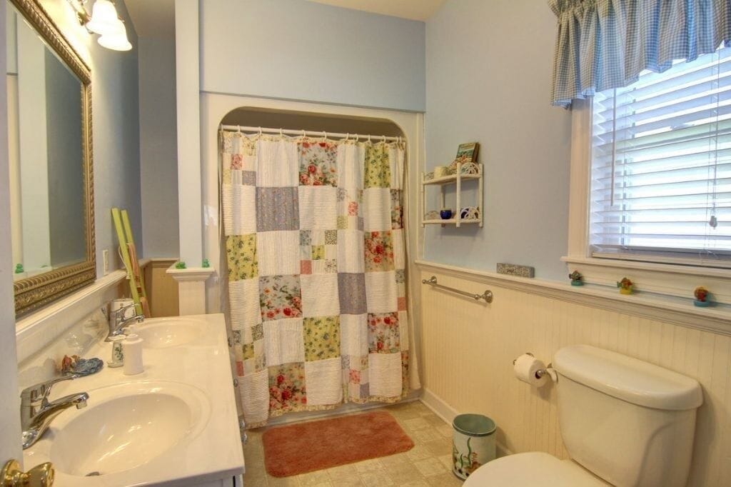 Un baño con lavamanos, inodoro y cortina de ducha.