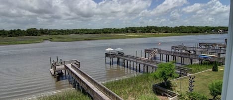 Udsigt over en flod med træmoler og en græsplæne.