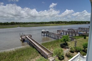 Une vue sur le fleuve, avec des quais en bois et une zone herbeuse.