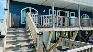 A wooden staircase leading to a covered porch with a railing.