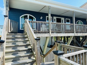 A wooden staircase leading to a covered porch with a railing.