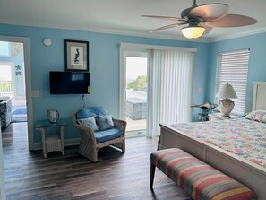 A bedroom with a bed, a chair, a bench, a television, and a ceiling fan. - Serenity's Star 4 Bedroom Home by RedAwning (Supply)