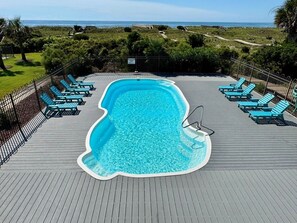 A swimming pool with a deck, surrounded by a fence, and overlooking a beach. - Serenity's Star 4 Bedroom Home by RedAwning (Supply)