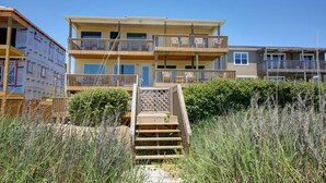 A multi-story building with a wooden staircase leading to a balcony.