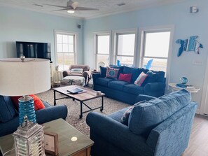 A living room with a blue sofa, a coffee table, a lamp, and a TV.