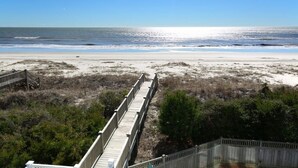 A beach with a wooden boardwalk leading to the shore. - The Seventh Day 6 Bedroom Home by RedAwning (Supply)
