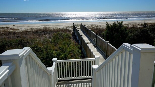 A wooden boardwalk leading to a beach with a clear view of the ocean. - The Seventh Day 6 Bedroom Home by RedAwning (Supply)