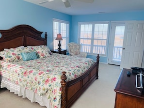 A bedroom with a large bed, a chair, a desk, and a window with blinds. - Victoria - 3 Br Home (Supply)