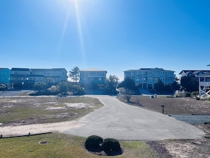 Um bairro residencial com céu claro, calçada pavimentada e casas de vários andares.