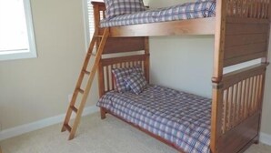 A bunk bed with a ladder, plaid bedding, and a window in the background. - Welcome  4 Bedroom Home by RedAwning (Supply)