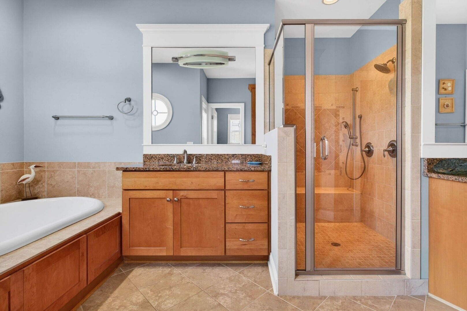 Une salle de bain avec une douche, un lavabo et des meubles en bois.