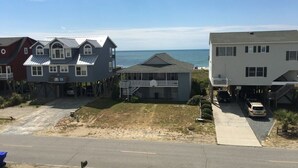 A residential area with houses, a road, and a beach in the background. - Best Day Ever 4 Bedroom Home by RedAwning (Supply)