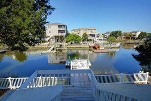 A waterfront property with a dock, a small boat, and a row of houses.