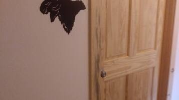 A wooden door with a keyhole and a wall decal of a moose head.