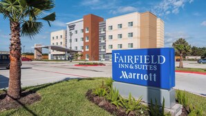 Une enseigne d’hôtel Fairfield Inn & Suites Marriott, avec un bâtiment moderne en arrière-plan.
