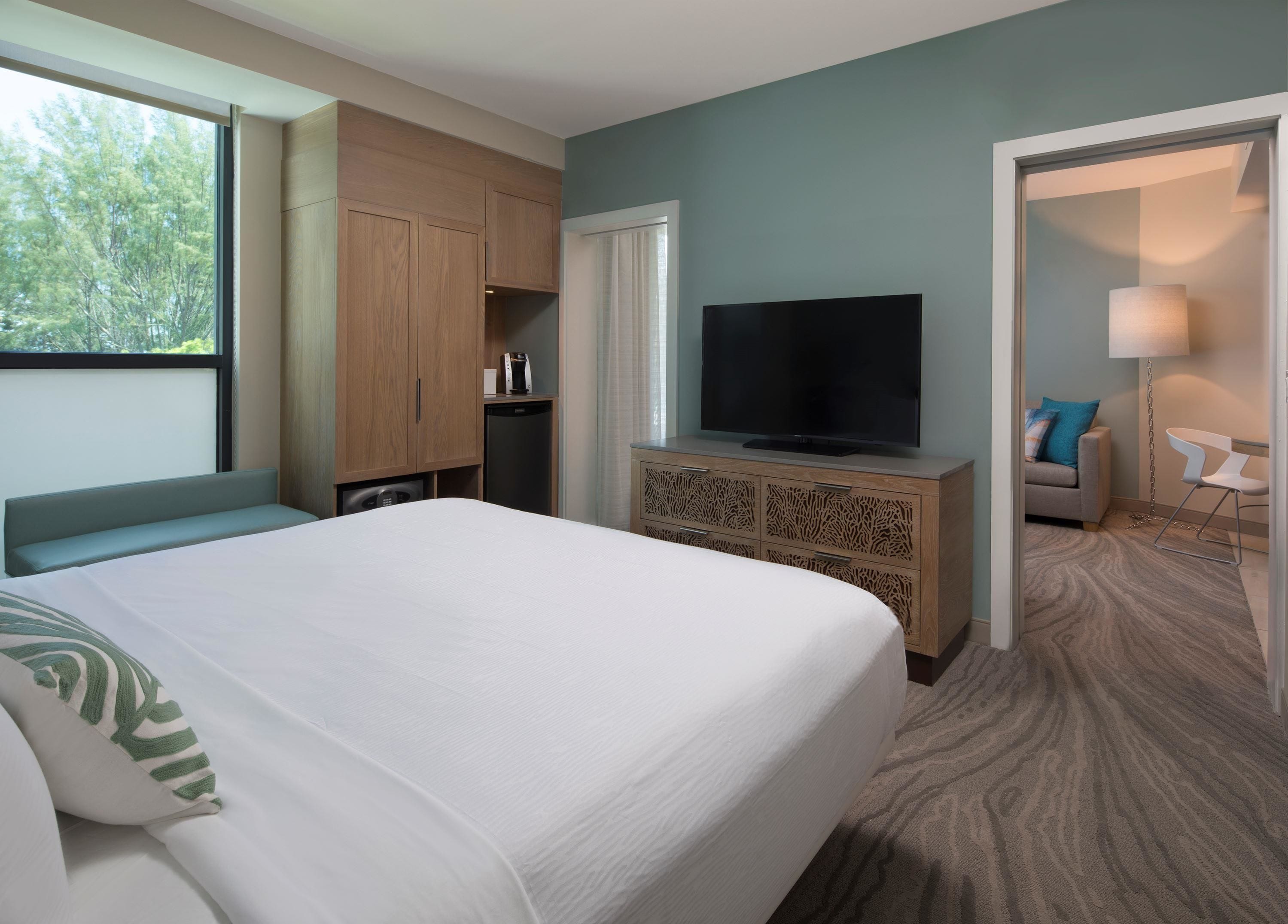 Une chambre d’hôtel équipée d’un lit, d’une télévision, d’une machine à café et d’une armoire.