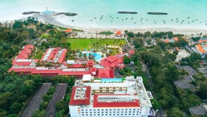 An aerial view of a resort with multiple buildings, a beach, and boats. - Holiday Inn Express Baruna Bali by IHG (Kuta)