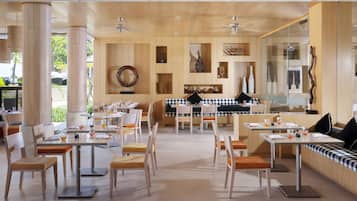 Een restaurant met houten wandpanelen, verschillende eettafels en stoelen.