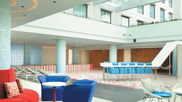 A spacious lobby with a high ceiling, seating areas, and a slide.