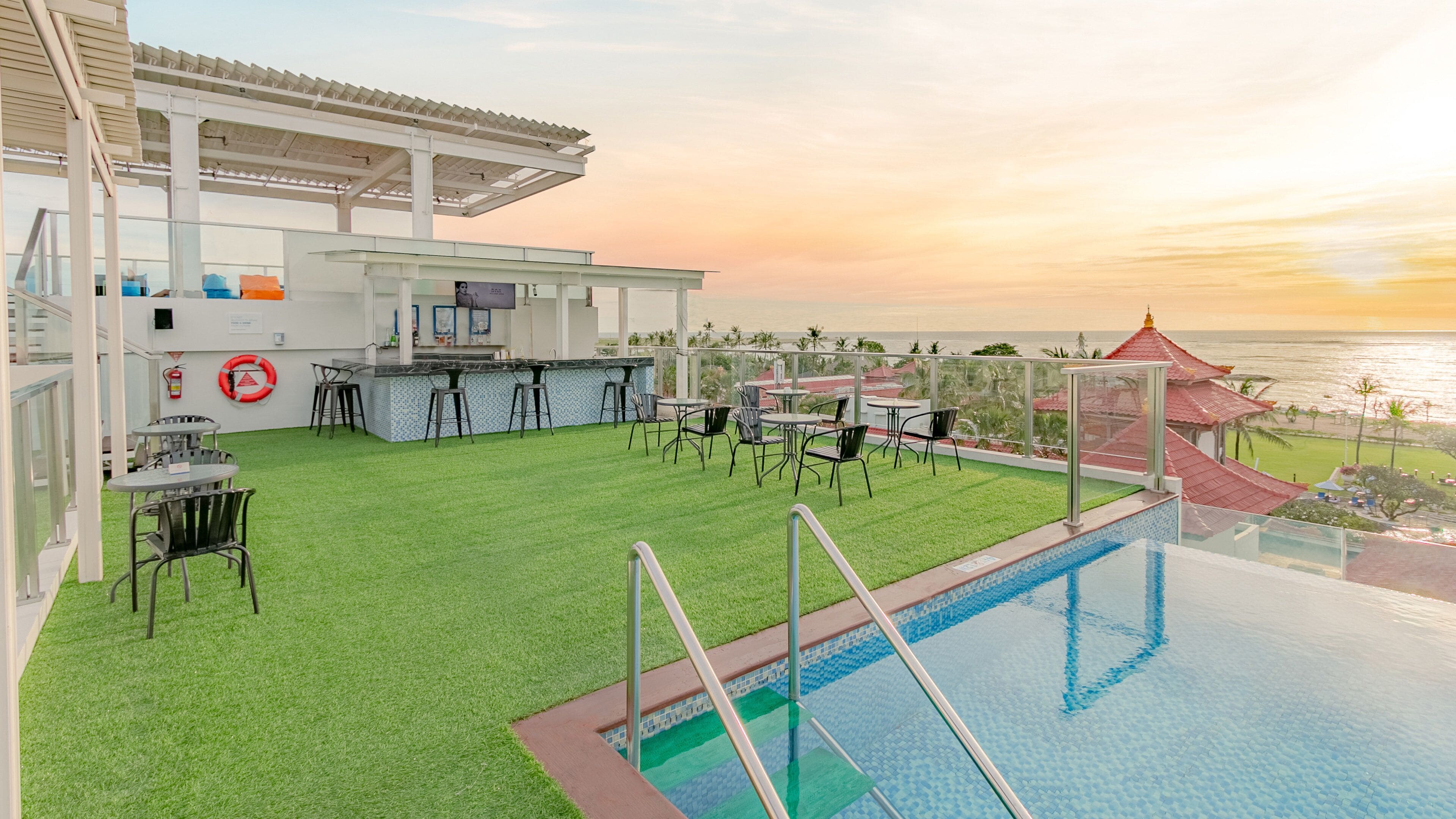 Um terraço com bar, piscina e área de estar.