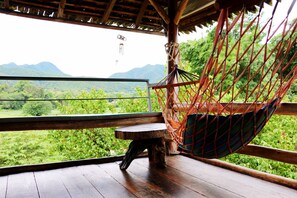 A hammock chair with a view of a lush green landscape and mountains in the background. - UP2U Guesthouse - Hostel (Pai)