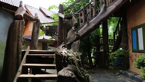 A rustic wooden staircase leading up to a traditional building with a tiled roof. - UP2U Guesthouse - Hostel (Pai)