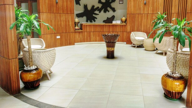 Un vestíbulo con paneles de madera, un mostrador de recepción y mobiliario de mimbre.