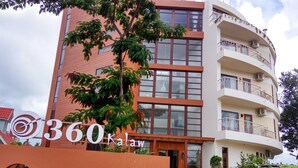 Un edificio moderno con un letrero que dice "360 Kalaw" y un ventanal circular.