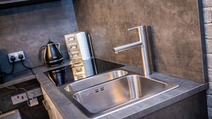 A modern kitchen with a stainless steel sink, a kettle, and a coffee maker. - James Place @ Dowlais (Merthyr Tydfil)