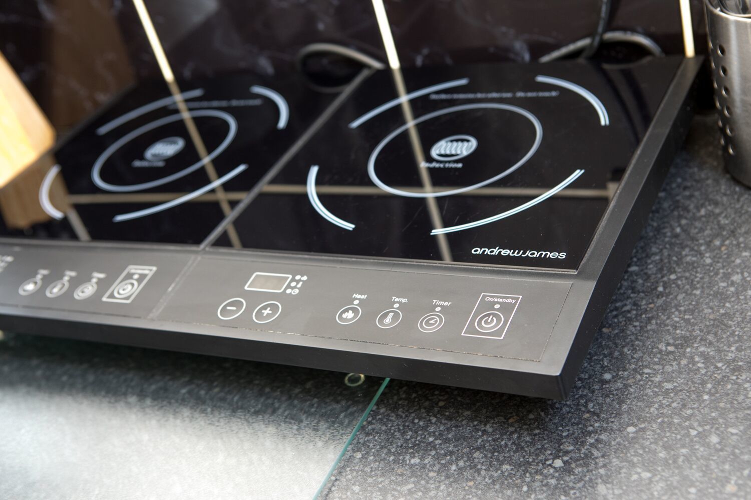 Een moderne inductiekookplaat met een digitaal bedieningspaneel en een strak zwart design.