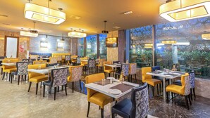 A restaurant with multiple tables and chairs, large windows, and a modern interior design. - CJ Pallazzio (Salem)