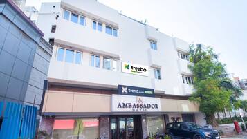 Un bâtiment moderne avec une enseigne indiquant « Trend Hotels » et « Ambassador Hotel ».