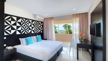 A modern hotel room with a large bed, a desk, a flat-screen TV, and a balcony with a view of palm trees.
