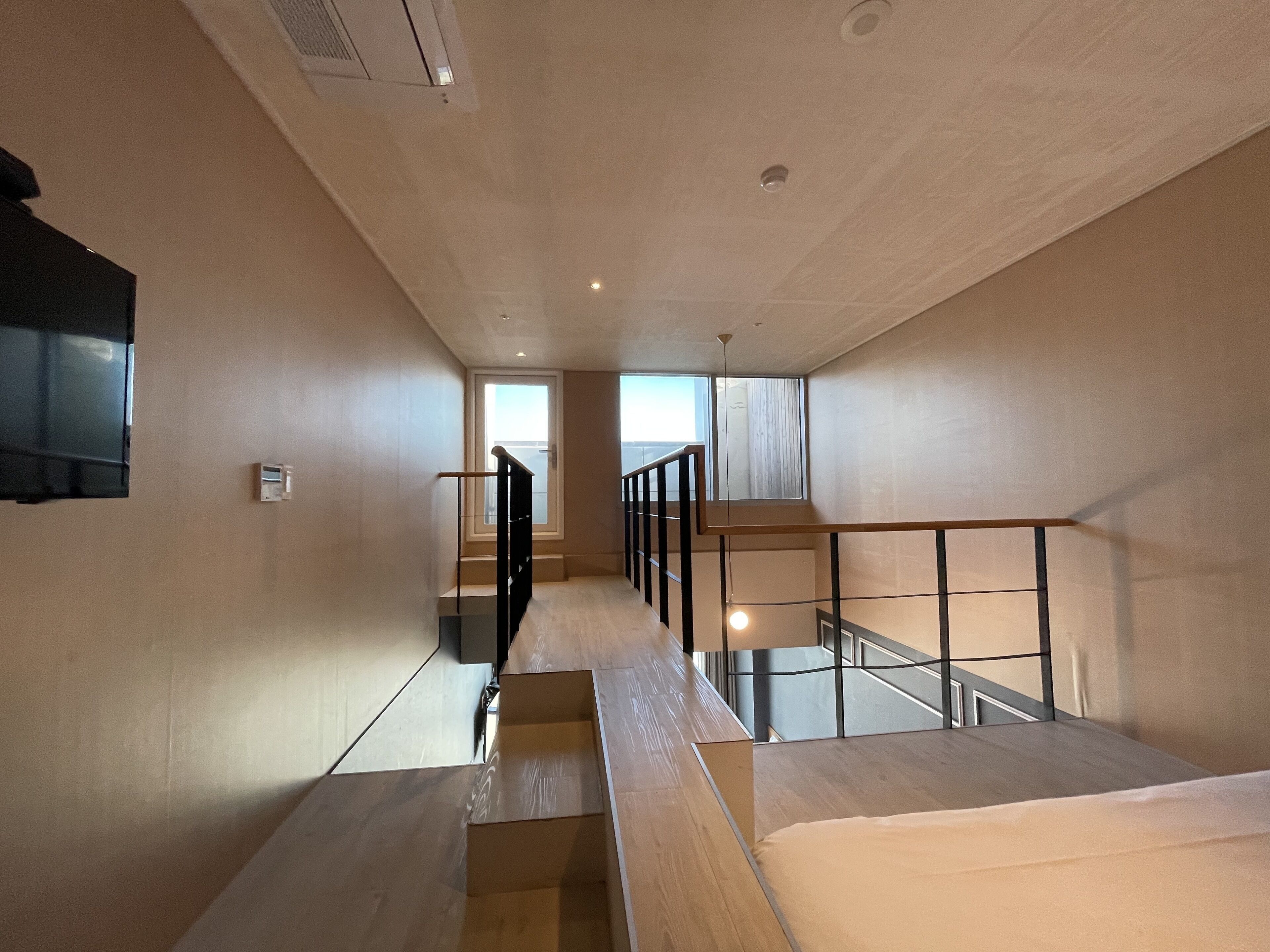 Ein modernes Interieur mit einer Treppe, die zu einem Balkon führt.