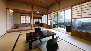 A traditional Japanese room with tatami flooring, a low table, and sliding doors. - Mizuno Ryokan (Karatsu)
