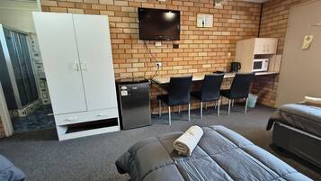 A room with a bed, a desk, a TV, and a wardrobe.