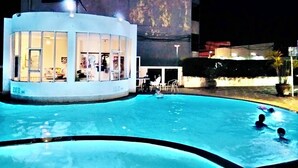 Una piscina con un edificio al lado.