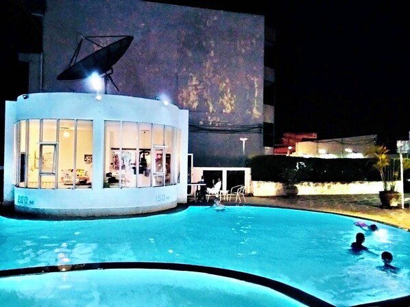 Una piscina con un edificio al lado.